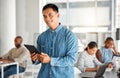 Portrait of a cheerful mixed race businessman working on a digital tablet at work. Happy hispanic man smiling while Royalty Free Stock Photo