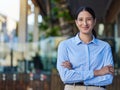 Portrait of a cheerful mixed race smiling businesswoman making with arms folded outside. Young hispanic woman business Royalty Free Stock Photo