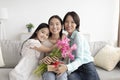 Portrait of cheerful multi generation Asian family with flowers and gift box celebrating Mother& x27;s Day at home Royalty Free Stock Photo