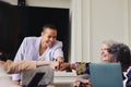 Portrait of cheerful multiracial LGBTQ mid adult woman fist bumping colleagues in meeting and smiling