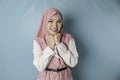 Portrait of a cheerful Muslim Asian woman standing and smiling at the camera,  on blue background Royalty Free Stock Photo
