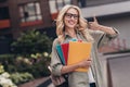 Portrait of cheerful nice lady hold materials supplies hand finger demonstrate thumb up street outside