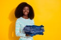 Portrait of cheerful nice person hold stack jeans toothy beaming smile isolated on yellow color background