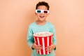 Portrait of cheerful nice schoolchild hands hold big popcorn bucket watch movie 3d glasses isolated on beige color Royalty Free Stock Photo