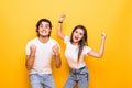 Portrait of cheerful people man and woman in basic clothing smiling and clenching fists like winners or happy people isolated over Royalty Free Stock Photo