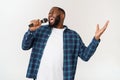 Portrait of cheerful positive chic handsome african man holding microphone singing song. Isolated on white background. Royalty Free Stock Photo