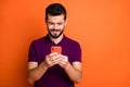 Portrait of cheerful positive guy use his cell phone chatting with social media friends comment reposts wear modern Royalty Free Stock Photo