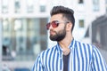 Portrait of cheerful positive stylish student guy in glasses with a mustache and beard outdoors. The concept of Royalty Free Stock Photo