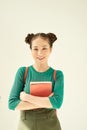 Portrait of a cheerful pretty asian girl holding books and looking at camera isolated over light background Royalty Free Stock Photo