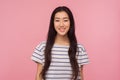Portrait of cheerful pretty asian girl with long brunette hair in striped t-shirt looking at camera with toothy smile Royalty Free Stock Photo