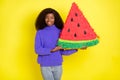 Portrait of cheerful pretty dark skin person holding big paper collage of watermelon isolated on yellow color background Royalty Free Stock Photo