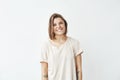 Portrait of cheerful pretty tattooed girl smiling biting lip looking at camera over white background. Royalty Free Stock Photo