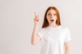 Portrait of cheerful pretty young woman open mouth having idea, pointing with finger up, looking at camera on white Royalty Free Stock Photo