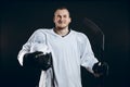 Handsome hockey player. Smiling at camera isolated on black background.