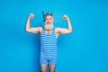 Portrait of cheerful retired pensioner sailor with his muscles laughing wearing striped swim wear isolated over blue Royalty Free Stock Photo