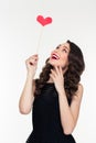 Portrait of cheerful retro styled young woman with heart booth