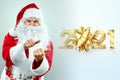 Portrait of a cheerful Santa Claus in a red suit on a light background with the gold numbers 2021.mixed media. Concept for Royalty Free Stock Photo