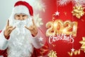 Portrait of a cheerful Santa Claus in a red suit on a light background with the gold numbers 2021.mixed media. Concept for Royalty Free Stock Photo