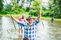 Portrait of cheerful senior man fishing. Excited senior man fisherman in cowboy hat with fishing rod, spinning reel on Royalty Free Stock Photo