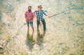 Portrait of cheerful senior man fishing. Grandfather and son fishermans. Young man and an old man fishing for spinnings Royalty Free Stock Photo