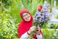 Cheerful senior muslim woman holding flowers