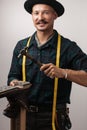 Portrait of cheerful shoemaker hammering on a shoe.