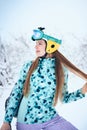 Portrait of cheerful skier girl in blue sweater and yellow helmet