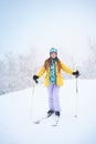 Portrait of cheerful skier girl in yellow jacket