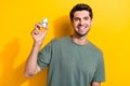 Portrait of cheerful smart guy with stubble wear stylish t-shirt hold mondey get passive income isolated on yellow color