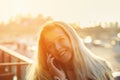 cheerful smiling attractive young woman with blonde hair smiling and talking on phone Royalty Free Stock Photo