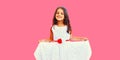 Portrait of cheerful smiling little girl child having fun wearing white dress on pink background Royalty Free Stock Photo