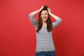 Portrait of cheerful smiling young woman in casual striped clothes standing putting hands to head isolated on bright red Royalty Free Stock Photo