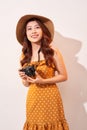 Portrait of cheerful smiling young woman taking photo with inspiration and wearing summer dress. Girl holding retro camera. Model Royalty Free Stock Photo