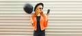 Portrait of cheerful smiling young woman taking selfie with smartphone and black balloon wearing round hat, red jacket on Royalty Free Stock Photo