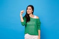 Portrait of cheerful smirked young woman in green casual clothes gesturing demonstrating size with workspace isolated on Royalty Free Stock Photo