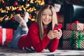 Portrait cheerful teenage girl surfing cell phone features to get discount in app for new year sale isolated on home Royalty Free Stock Photo