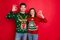 Portrait of cheerful two people student with brunette wavy hair hug embrace show ok sign sales wear funny deer christmas