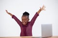 Portrait of cheerful woman with arms raised by laptop Royalty Free Stock Photo
