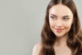 Portrait of cheerful woman with clear skin and healthy curly hair on gray background. Beautiful face close up. Royalty Free Stock Photo