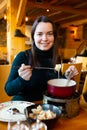 Young adult woman eating fondue at restaurant Royalty Free Stock Photo