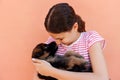 Portrait of a cheerful woman holding and looking at an adorable small puppy Royalty Free Stock Photo