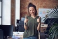 Portrait of cheerful woman, interior designer or architect smiling at camera, showing thums up while standing in modern