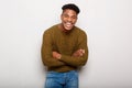 Cheerful young african american man laughing with arms crossed by gray wall Royalty Free Stock Photo