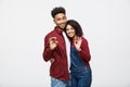 Portrait of a cheerful young african couple standing together and showing ok gesture isolated over white background Royalty Free Stock Photo