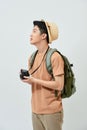 Portrait of cheerful young Asian tourist man holding digital camera and taking photo when standing over white background Royalty Free Stock Photo