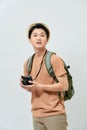 Portrait of cheerful young Asian tourist man holding digital camera and taking photo when standing over white background Royalty Free Stock Photo