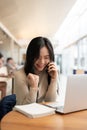 A portrait of a cheerful young Asian woman rejoicing after receiving good news over the phone Royalty Free Stock Photo