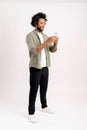 Portrait of cheerful young black guy sending message on mobile phone against white background. Happy African-American Royalty Free Stock Photo