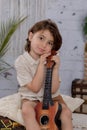 A vertical shot of a young boy with its ukulele Royalty Free Stock Photo