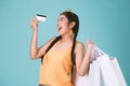 Portrait of cheerful young brunette woman holding credit card and shopping bags Royalty Free Stock Photo